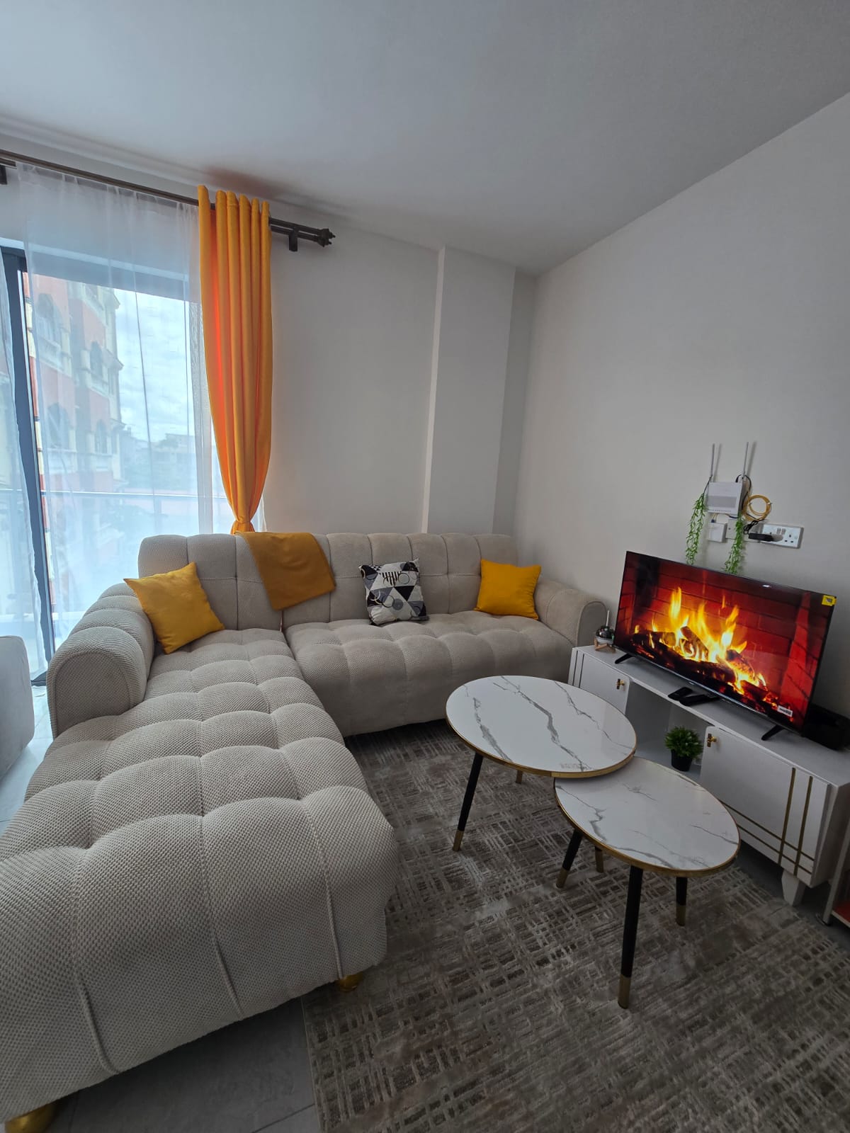 Sunlit living room with plush sofas and smart TV
